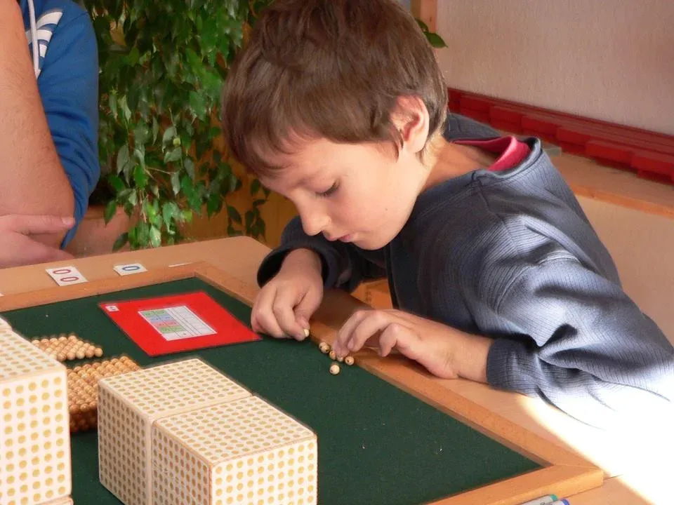 Ein Schüler arbeitet konzentriert mit Montessori-Material