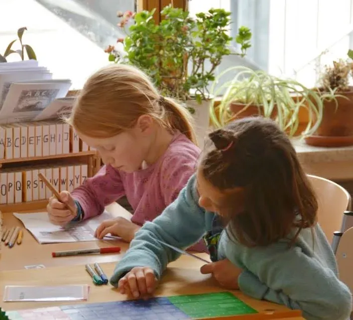 Schülerinnen lernen gemeinsam an einem Tisch